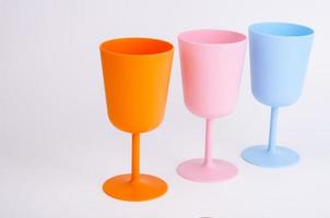 Colored plastic wine glasses on white background. photo