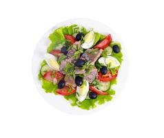 Salad of fresh vegetables, egg, canned fish and olives. photo
