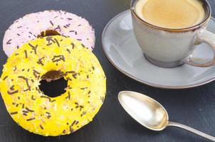 Cup of espresso with fresh pastries for breakfast on black stone background. photo