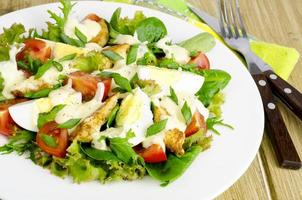 Salad of fresh vegetables, eggs, chicken meat with white sauce. photo