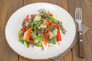 Fresh vegetable salad with crab sticks. photo