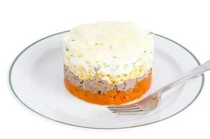 Portion layered salad with fish, carrots and eggs. photo