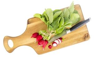Bunch of fresh red radish on wooden cutting board for cooking. photo