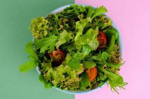 Bowl of mixed salad on bright, color background. photo