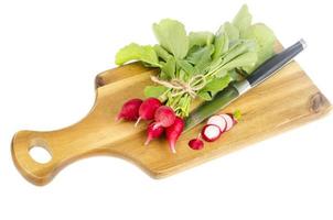 Bunch of fresh red radish on wooden cutting board for cooking. photo