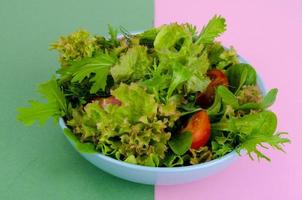 Bowl of mixed salad on bright, color background. photo