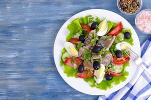 ensalada de verduras frescas, huevo, conservas de pescado y aceitunas. foto