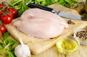 Fresh raw chicken fillet and vegetables prepared for cooking. photo