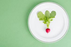 rábano rojo en un plato. concepto de comida vegetariana, diseño, menú. foto