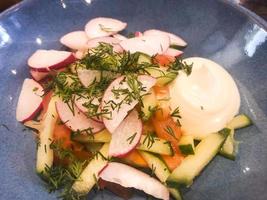 ensalada de verduras frescas en un plato azul. foto