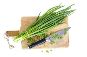 Use of fresh green onions in cooking, kitchen wooden board. photo