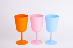 Colored plastic wine glasses on white background. photo