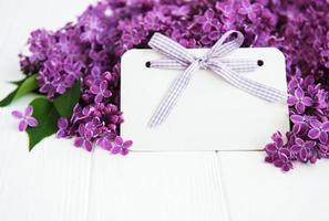 Lilac flowers with greeting card on a table photo