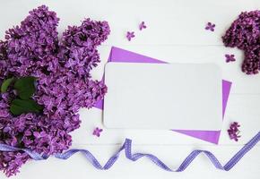 flores lilas con tarjeta de felicitación en una mesa foto