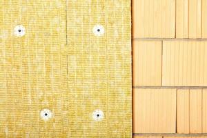 Fragment of thermal insulation of a brick wall of a house with mineral wool. photo