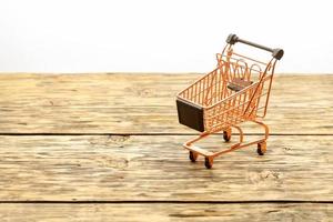 Metal shopping basket on a striped wooden background. photo