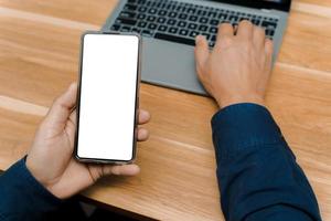 Blank mockup, white screen, mobile phone.men holding text messages using mobile relaxing on sofa at home. empty space background for ads marketing business photo