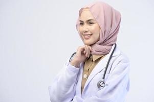 Female muslim doctor with hijab over white background studio. photo