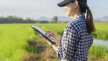 Young female smart farmer with tablet on field,High technology innovations and smart farming photo