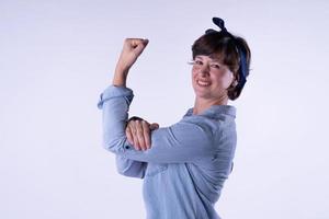 chica de pelo corto que muestra un fuerte músculo del brazo aislado. foto