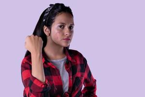 Long haired girl showing painting symbol on face isolated on lilac pastel background. photo