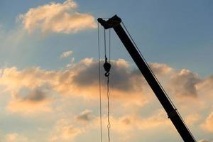 mobile crane operating, silhouettes at sunset photo