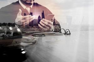 double exposure of justice and law concept.Male judge in a courtroom with the gavel,working with smart phone,digital tablet computer docking keyboard on wood table,London architecture city photo