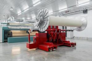 lifting hydraulic machine lifts large coils. textile and spinning mill photo