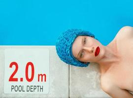 portrait of beautiful woman in pool cap laying by the swimming pool. Summer, wellness, recreation, travel concept photo