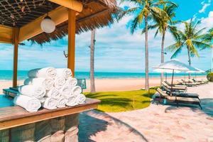 Hermosa playa tropical y mar con sombrilla y silla alrededor de la piscina en el complejo hotelero foto