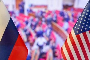 la bandera estadounidense y la bandera rusa en el fondo de muchas personas. bandera de estados unidos, bandera de rusia. los estados unidos de américa y la confrontación de la federación rusa. invasión de rusia a ucrania foto