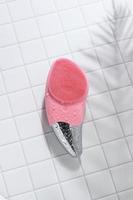 Peach facial sonic brush for massage on tile with water drops photo