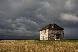 nubes de tormenta pradera cielo casa de piedra foto