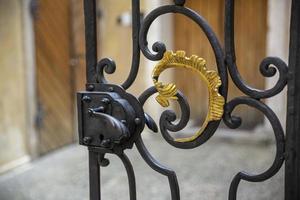 Close-up of an old semi-open wrought iron gate with ornaments. photo