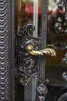 Close-up of an old semi-open wrought iron gate with ornaments. photo