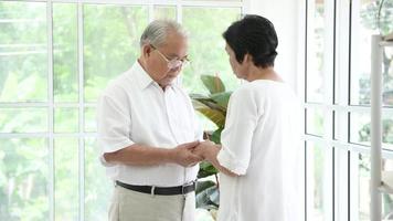 A senior elderly couple are hugging in home video