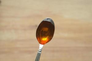 Top view of fresh honey with spoon on table photo