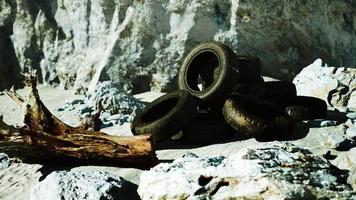 old tires overgrown embedded in the sand photo