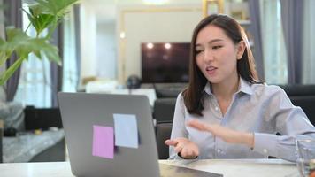 A beautiful young business woman  is making video conference call via computer at home , business technology concept .