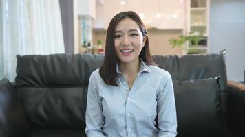 Headshot screen view of young Asian businesswoman is online using Video conference with partners or business coworkers from her home .