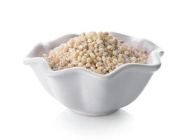 Heap of pearl barley in a bowl on white background photo