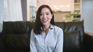 Headshot screen view of young Asian businesswoman is online using Video conference with partners or business coworkers from her home .