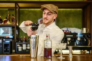 barman masculino exprimiendo limón en un cóctel en un pub foto