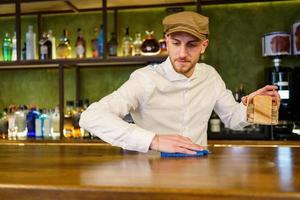 Bartender cleaning counter in a nice pub photo