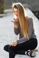 Happy blonde girl smiling in urban background photo