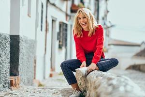 Smiling blonde girl with red shirt enjoying life outdoors. photo