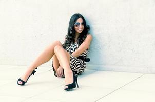 Funny Female model at fashion with high heels sitting on the floor photo