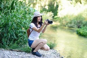 Hiker woman taking photographs with a mirrorless camera photo