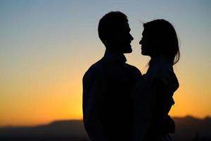 silueta de la novia y el novio en el fondo del atardecer foto