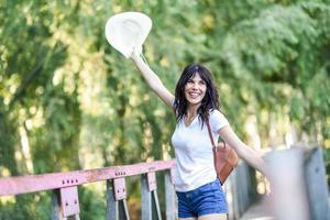 Woman with backpack standing on rural bridge. photo